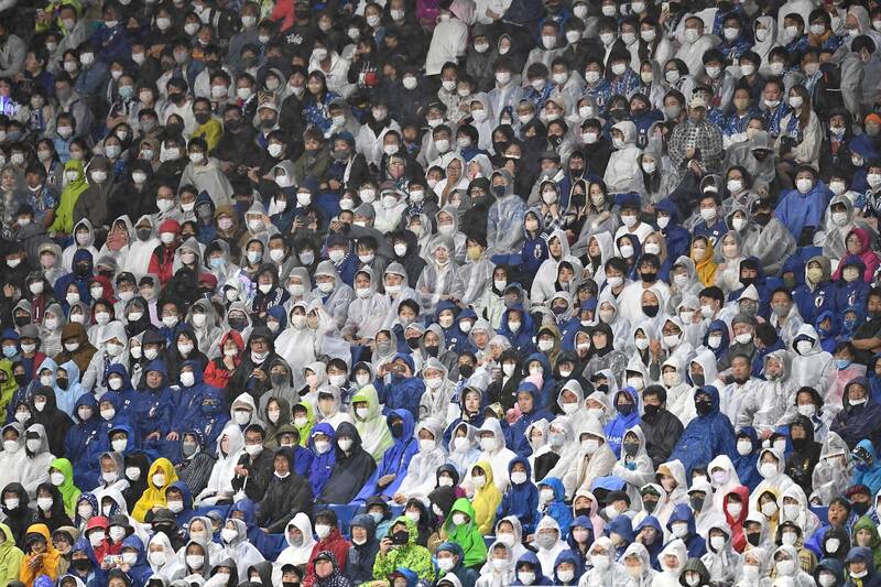 日本政府從未以武肺防疫為由強制民眾戴口罩，但深植人心的「從眾」與「自肅」觀念讓民眾自動自發戴好口罩。圖為6月14日在大阪府吹田足球場觀戰的球迷幾乎都戴著口罩。（法新社）