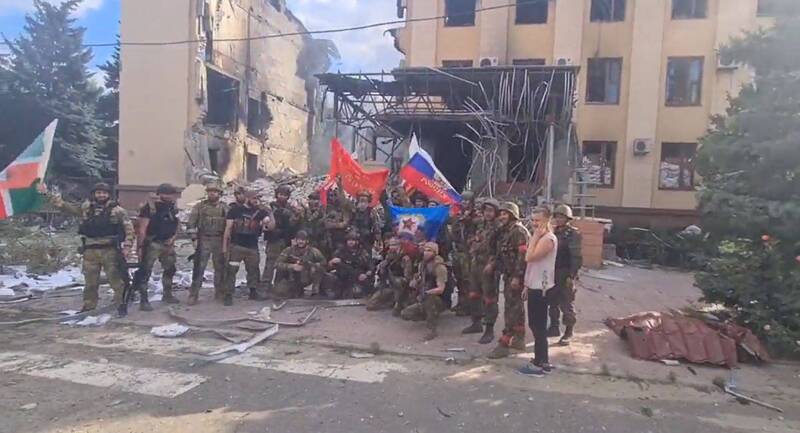俄軍與車臣士兵在利西昌斯克市政大樓高舉旗幟，烏克蘭在盧州最後大城利西昌斯克已遭俄羅斯控制。（圖擷自推特）