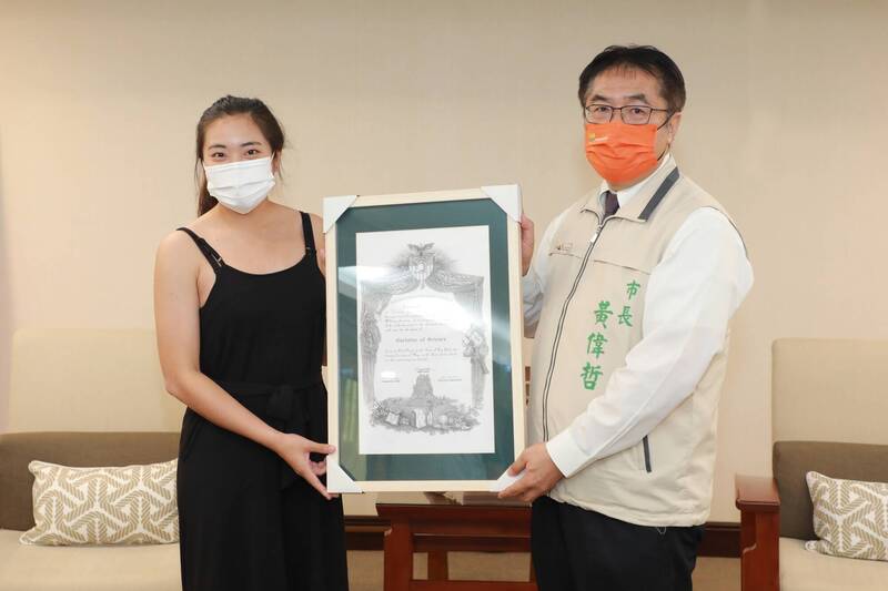 胡家琪（左）持美國西點軍校畢業證書與台南市長黃偉哲（右）合照分享榮耀。（台南市府提供）