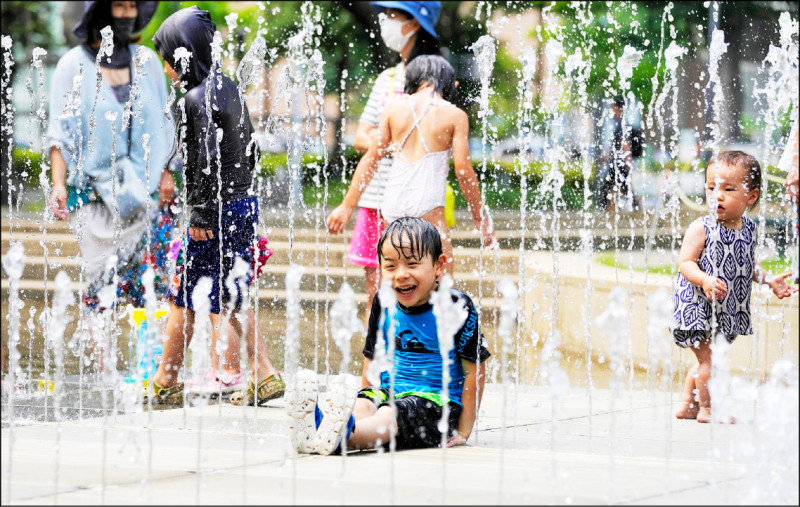 日本氣象廳6月宣布，2022年的梅雨季在全國大部分地區已經結束，包括東京地區，創下自1951年以來的最快紀錄。圖為6月東京都中野區一個公園，孩童們正在烈日和高溫下開心戲水。（歐新社）