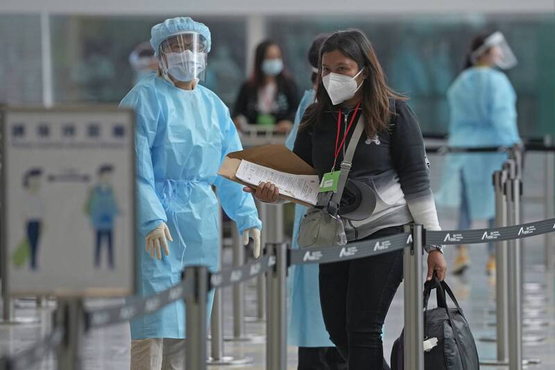 香港第5波疫情升温，图为香港国际机场的工作人员引导入境旅客入住防疫旅馆。（美联社）(photo:LTN)