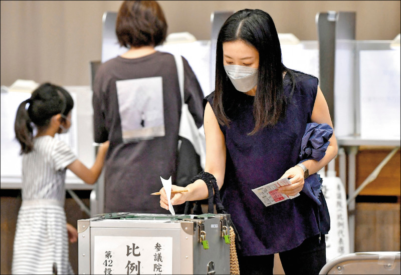 日本十日舉行參議院改選和補選，圖為東京一名女性選民投下神聖一票。（法新社）