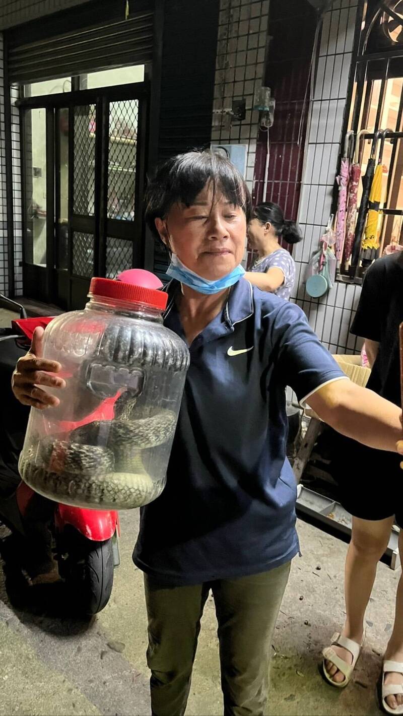 蕭富子抓完蛇後與戰利品自拍。（蕭富子提供）