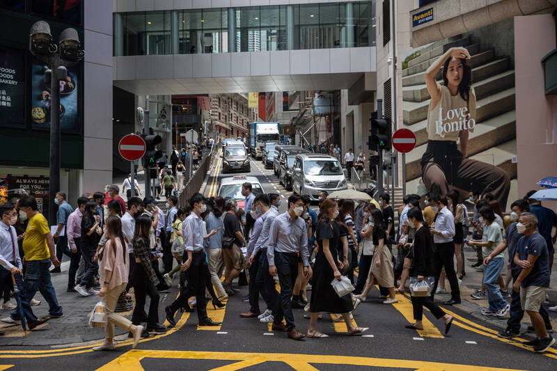 香港疫情持續升溫，民眾戴口罩防疫。（歐新社）