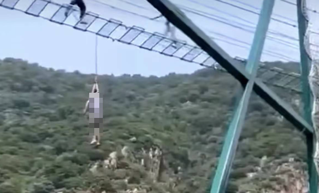 中国一名男子到蓟州九山顶风景区挑战「步步惊心」吊桥设施，过程中意外坠落，安全绳直接缠绕颈部，整个人就这样吊在半空中。（图翻摄自微博）(photo:LTN)