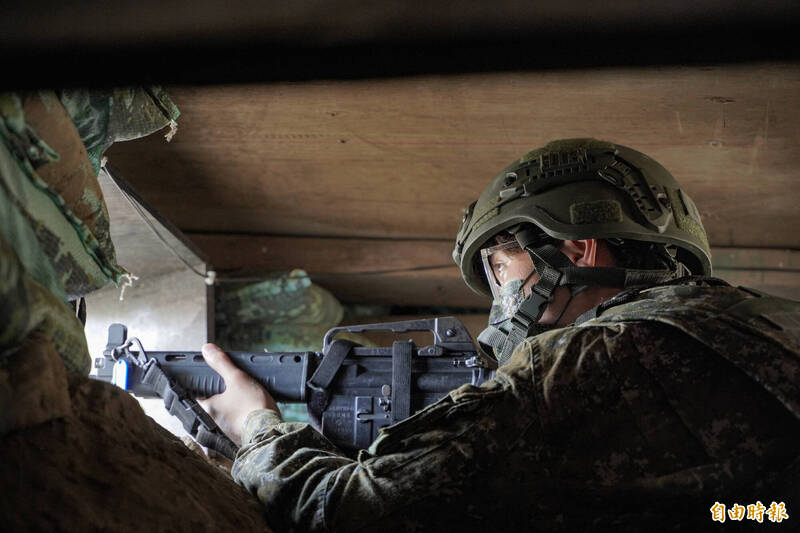 國軍109旅後備軍人於壕溝內持槍瞄準。（記者涂鉅旻攝）