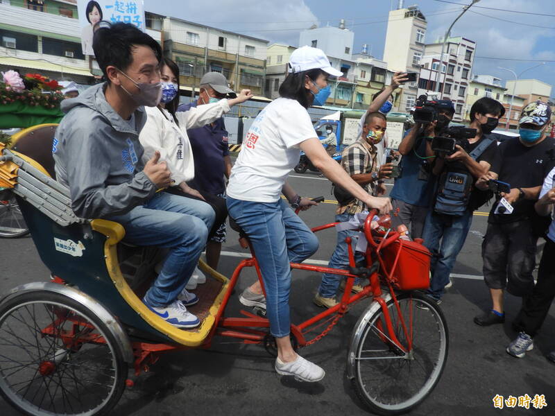 柯志恩騎著三輪車，上面載著兩名國民黨市議員。（記者葛祐豪攝）