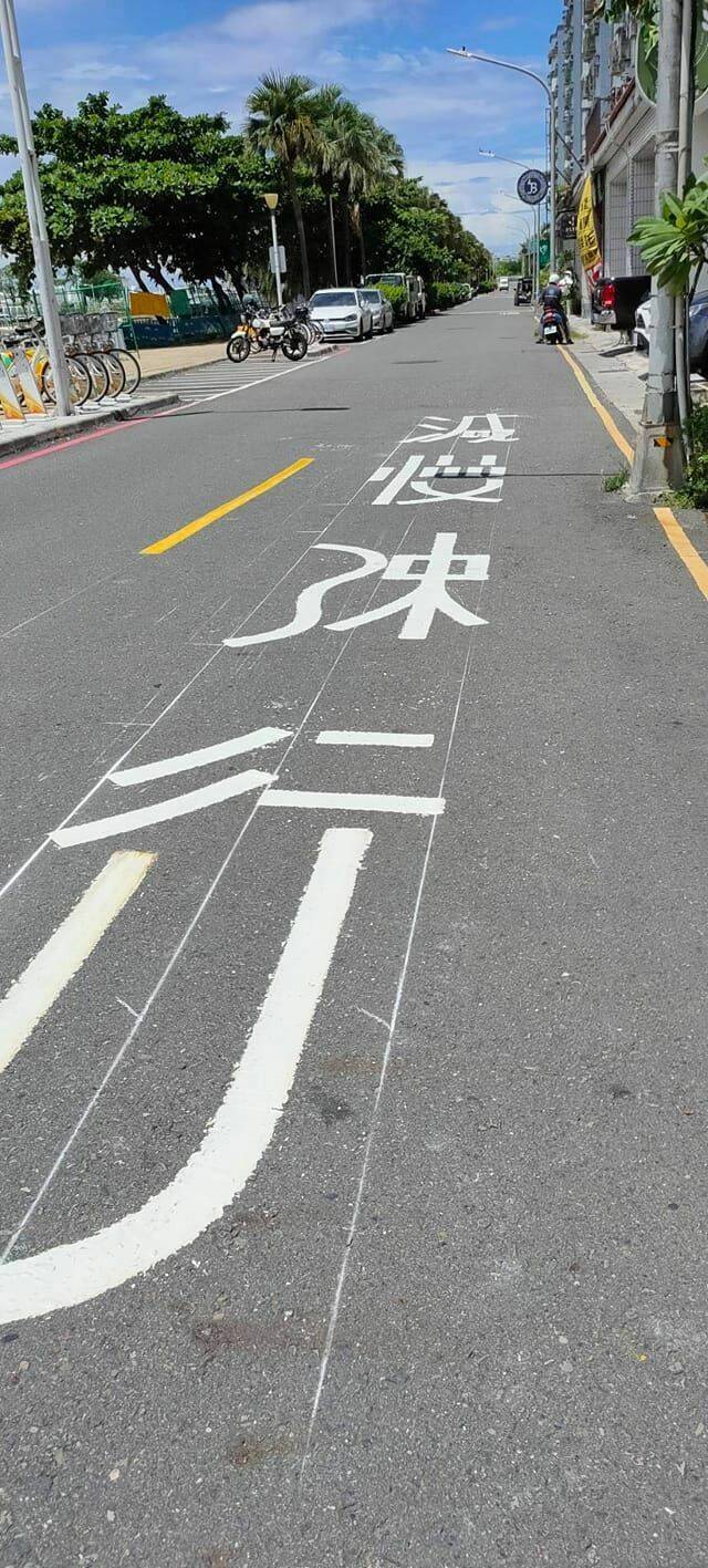 高雄中華五路的馬路上，出現「減慢速行」四個大字，「慢」跟「速」字還自創新寫法。（翻攝自曾麗燕臉書）