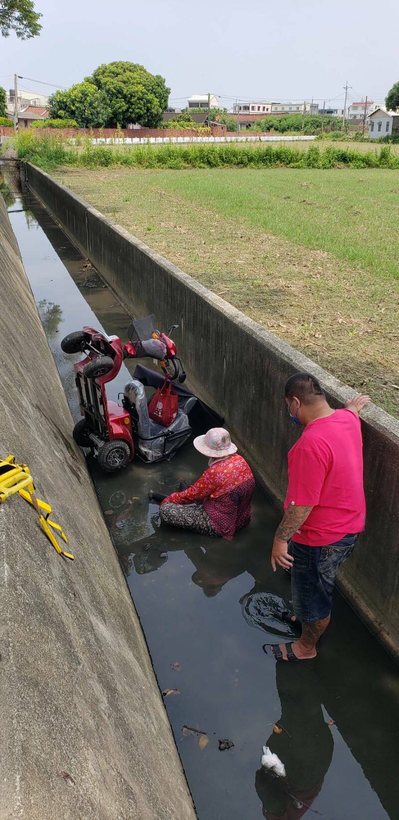 80歲老婦騎乘電動車，今午行經鹽水區坔頭港里1處大排時不慎摔落，下營消防隊獲報趕抵協助老婦上岸。（圖由民眾提供）