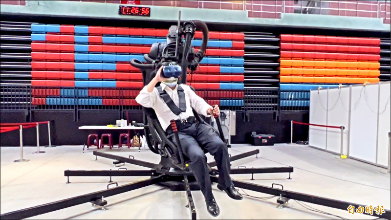 屏東縣長潘孟安坐上沉浸式機械手臂展開VR體驗，彷彿在空中欣賞恆春半島美景。（記者羅欣貞攝）