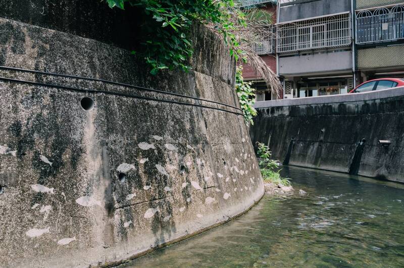 苗栗市內有不少大小圳溝，在地青年藝術家陳建成、陳安嘉、陳美聿、詹昀軒以高壓水槍局部清洗壁面，利用髒污和乾淨區域的對比，呈現魚兒、水草等圖案。（陳安嘉提供）