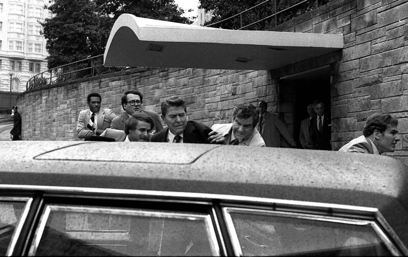 特勤人员在案发后将雷根总统（中）护送上车。（美联社）(photo:LTN)