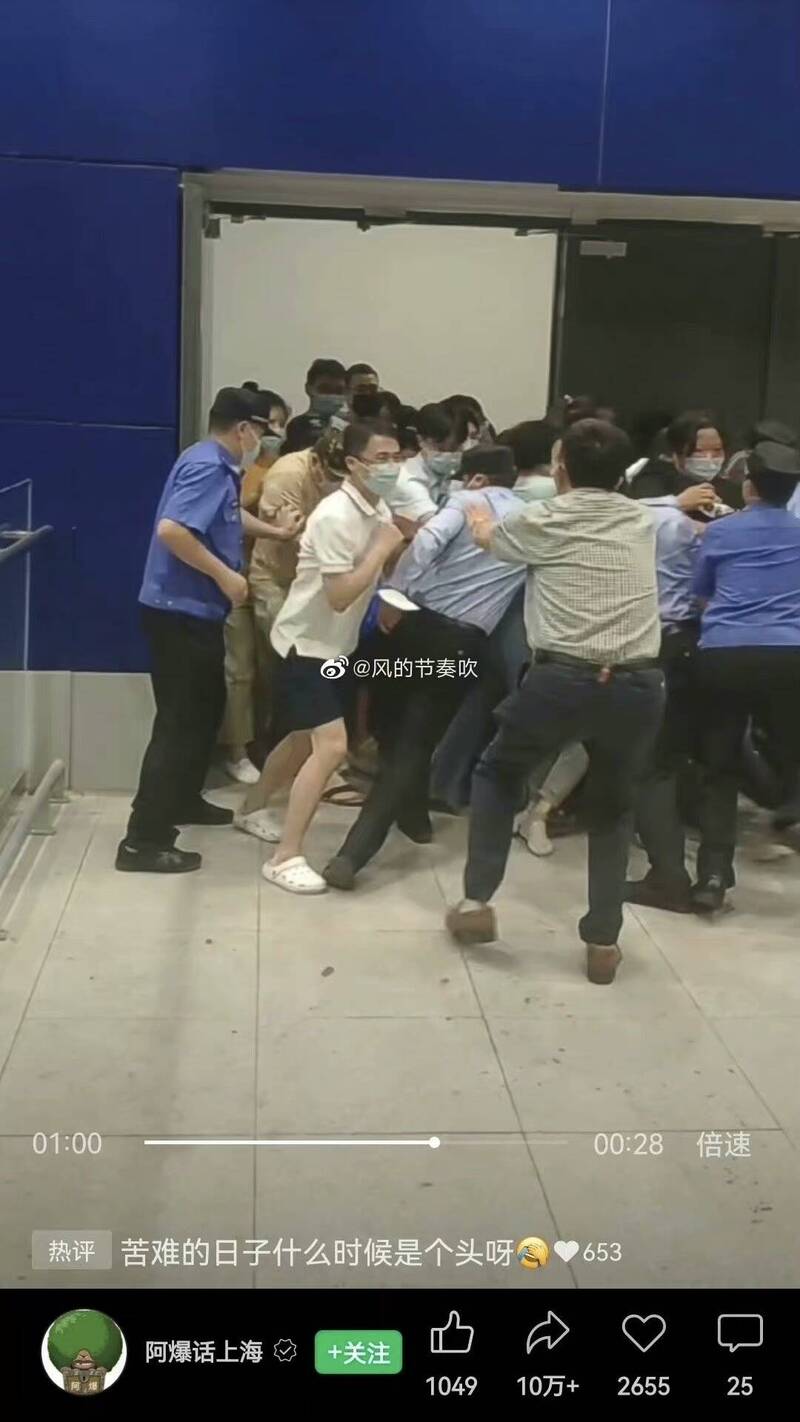Ikea卖场警卫试图关上铁门时，民众开始推挤，最终人群蜂涌而出。（图撷取自微博）(photo:LTN)