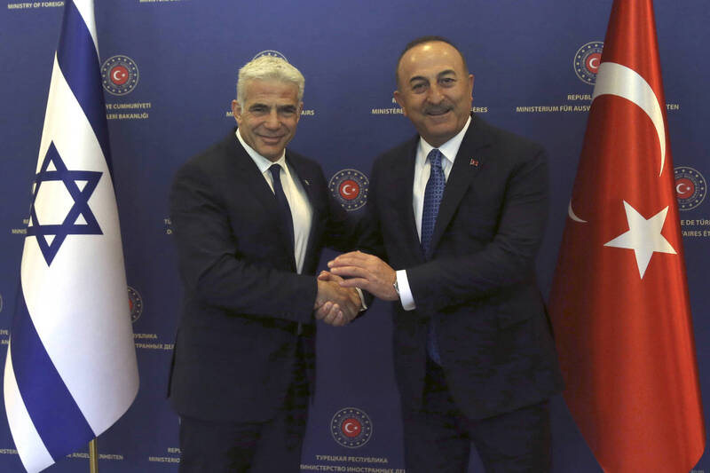 今年6月23日，土耳其外交部长卡夫索格鲁（右）与以色列总理拉皮德（左）握手合影。（美联社）(photo:LTN)