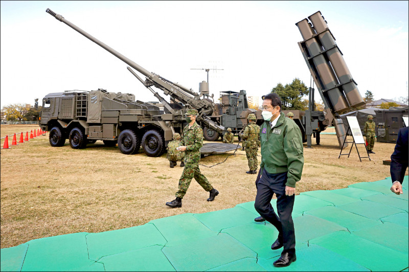 為因應台海局勢潛在巨變，日本政府擬擴大自衛隊長程巡弋飛彈部署。圖為日本首相岸田文雄去年底視察陸上自衛隊時，行經19式155公釐輪型自走砲及12式地對艦誘導彈等軍備。（路透檔案照）