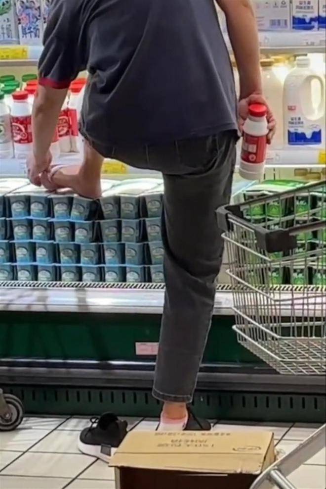 中国有消费者到超市消费，发现一名工作人员竟然赤脚踩在开放式冰柜底层的优格上，遂将其录影后曝光于网路，引发争议。（翻摄微博）(photo:LTN)