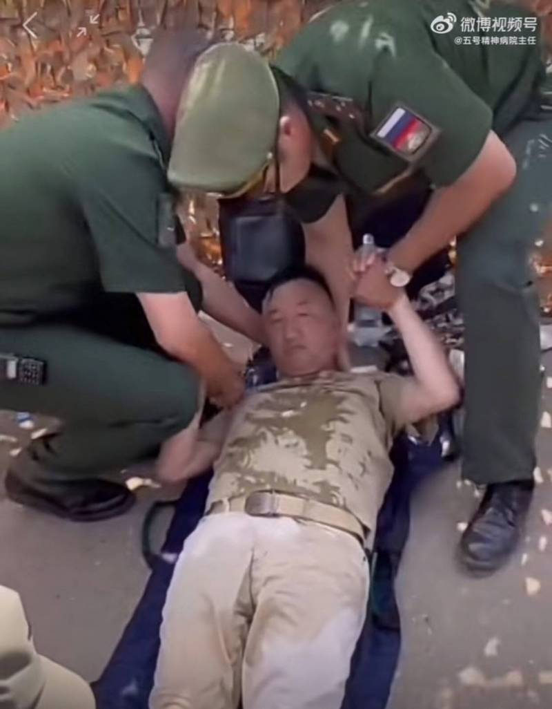 卢宇光四肢无力，得由旁人搀扶送上担架，裤子上还留有大片水渍。除了医护人员，还有两位疑似俄罗斯军官在一旁协助。（图撷取自微博）(photo:LTN)