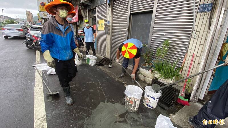 基隆清潔隊員在東明路清水溝卻挖出水泥。（記者盧賢秀攝）