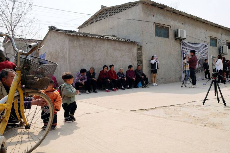 中国河南省一数据公司的工作人员为村民拍摄面部数据收集照片。（路透）(photo:LTN)