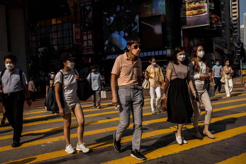 香港的武漢肺炎疫情持續擴散，民眾戴口罩防疫。（法新社）