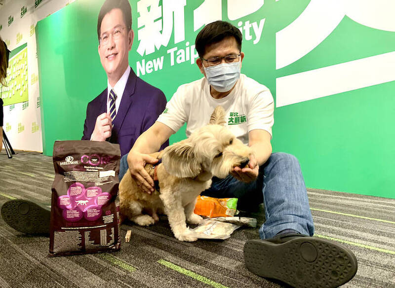 民進黨新北市長參選人林佳龍用零食，收買狗狗，與狗狗拉近距離。（林佳龍競選辦公室提供）