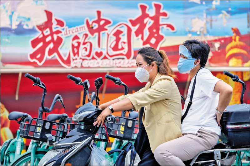 北京妇女六月骑车经过写有「我的中国梦」看板前。美国媒体分析，人口红利消失、经济衰退，加上军队腐化等因素，都可能让中国国家主席习近平主张的「中国梦」沦为「白日梦」。（美联社档案照）(photo:LTN)