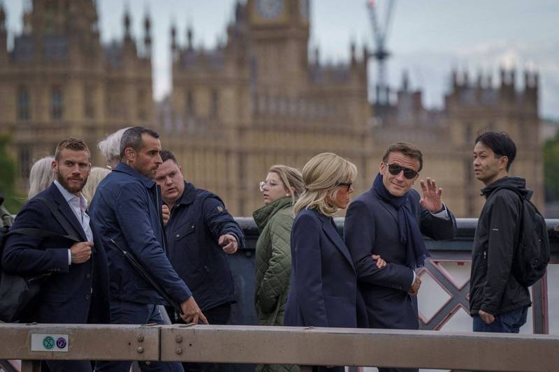 法国总统马克宏（右二）和第一夫人碧姬．马克宏（右三）到英国参加伊莉莎白二世国葬，18日提早抵达，一身轻装在随扈簇拥下现身伦敦街头，引起一阵骚动。（路透）(photo:LTN)