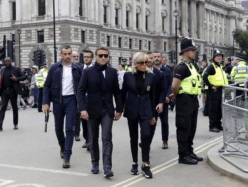 法国总统马克宏（前排左）和第一夫人碧姬．马克宏（前排右）赴英国参加女王伊莉莎白二世国葬，18日提早抵达伦敦，被人目击一身轻装在随扈簇拥下现身街头。（欧新社）(photo:LTN)