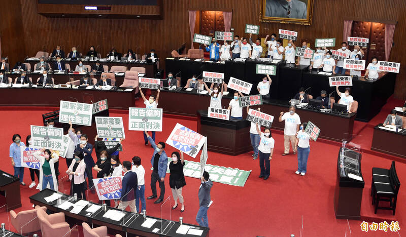 立法院23日開議，行政院長蘇貞昌出席施政報告及備詢，國民黨立法院團發動杯葛，占據主席台、發言台癱瘓議事，並要求蘇貞昌先道歉再報告，民進黨立法院黨團成員也舉標語反制。（記者廖振輝攝）