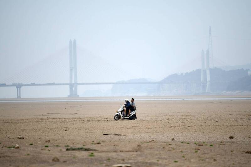 鄱阳湖水位创历史新低，中国民众在干涸的湖床上骑摩托车。（法新社）(photo:LTN)