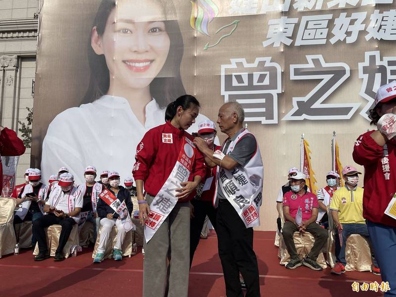 南市前副議長曾順良（前中右者）為女兒、東區市議員參選人曾之婕披上競選彩帶，象徵傳承民代使命。（記者王俊忠攝）