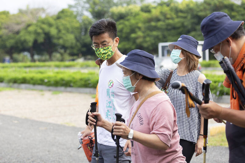 應邀擔任帕金森病友徒步環島活動「 誰帕誰 徒步環島」新竹站站長的民進黨新竹縣長參選人周江杰（左），今早陪同他罹病20多年的岳母在竹東河濱公園健走！（周江杰團隊提供）