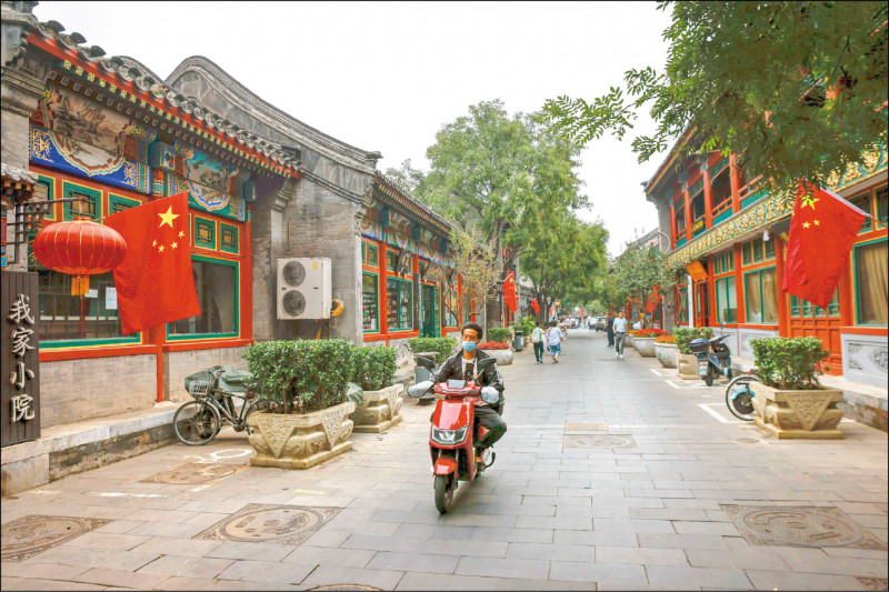 中共第廿次全国代表大会将届，中国一六一九个地区被列为中、高风险区，黄金週假期形同虚设。图为北京一条街道因十月一日国庆日在道路两旁插上国旗。（欧新社）(photo:LTN)