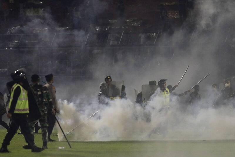 维安警力上前将球迷驱离，警方也朝人群发射催泪弹。（美联社）(photo:LTN)