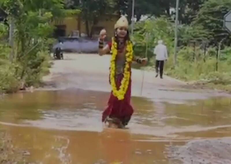 印度一名9岁小女孩利用节庆期间，扮成印度教女神杜尔嘉（Durga）行走在充满坑洞与积水的道路上，希望成功引起民众对当地基础建设的关注。（撷自网路）(photo:LTN)