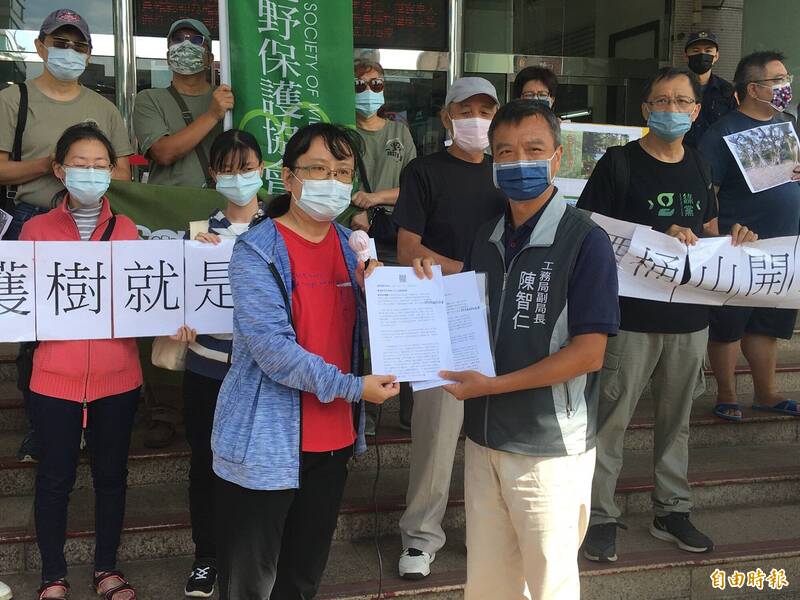 桃園護樹行動聯盟召集人吳凱琳將陳情書遞給工務局副局長陳智仁。（記者謝武雄攝）