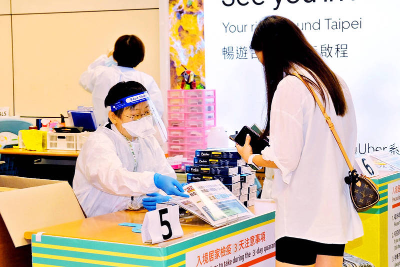 A woman arriving at Taiwan Taoyuan International Airport receives information about COVID-19 protocols on Sept. 29.
Photo: CNA