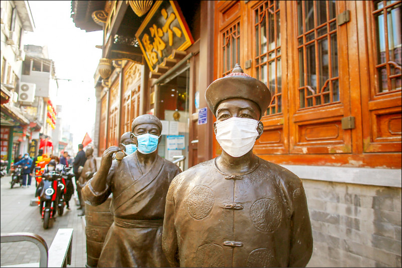 图为一至七日的中国「十一黄金週」连假期间，首都北京市「六必居酱园」门外的雕像也被戴上口罩。（欧新社）(photo:LTN)
