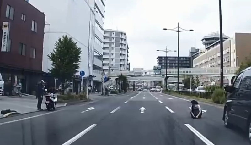 日本京都有一隻小黑貓闖入車道受傷，一位高中生見狀，勇敢跑進車道將小貓抱回路邊，勇敢且溫柔的行徑讓日本網友激賞。（翻攝推特）