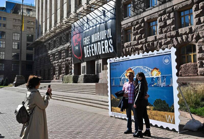 乌克兰画家将克里米亚大桥爆炸绘制成巨型看板，展示于乌克兰首都基辅市中心，吸引乌克兰民众前往拍照打卡。（法新社）(photo:LTN)