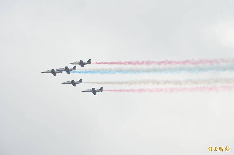 空軍雷虎特技小組衝場，5架AT-3教練機施放象徵國旗顏色的紅藍白彩煙，飛越總統府上空，不僅展現空軍優異的飛行技能，更為今日的國慶大會劃下完美的句點。（記者田裕華攝）