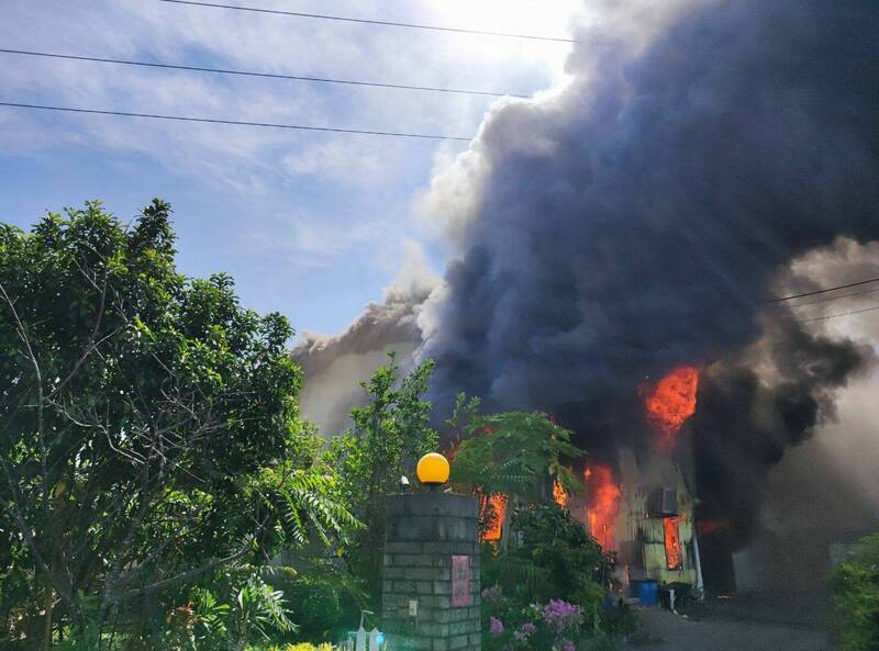 台中霧峰六股路一間鐵皮廠房今天早上起火燃燒，火舌不斷從廠房內竄出，濃煙直竄天際。 （記者陳建志翻攝）