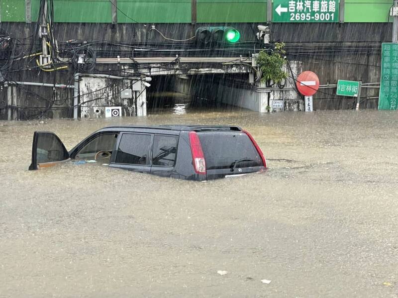 尼莎颱風外圍環流影響，帶來強降雨，一輛黑色休旅車今天下午3點駛入新北汐止區吉林街與福德三路口，由於車輛拋錨，駕駛嚴姓男子與乘客2人受困，目前人員獲救。（圖為新北市政府提供）