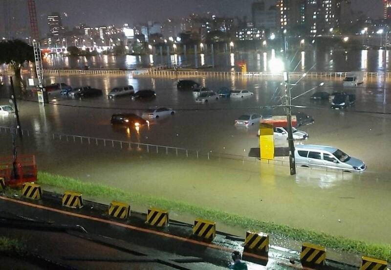 百齡橋下堤外停車場汪洋一片，上百輛車慘淪泡水車。（記者鄭名翔翻攝）