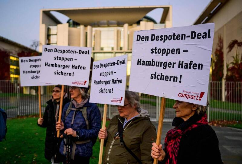 权益运动人士26日在德国柏林联邦总理府前，举牌要求阻止中国远洋运输集团投资汉堡港码头案。标语写着「阻止这项专制政权交易，维护汉堡港口的安全」。（法新社）(photo:LTN)