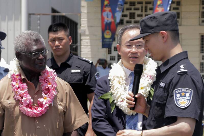 在首都荷尼阿拉一场典礼上，索罗门群岛苏嘉瓦瑞（左）与中国大使（右2）李明一起听中国警察致词。（法新社）(photo:LTN)