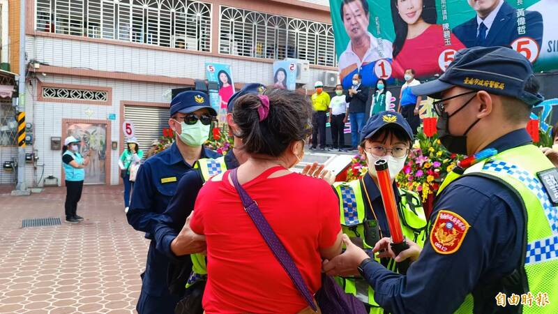 立法院長游錫堃至台南市新市輔選，致詞時提到「國民黨甘願成中華民國的一部分」，遭到紅衣婦人回嗆亂講，婦人隨即被警方架離。（記者劉婉君攝）