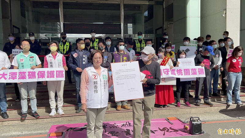 民眾黨桃園市長候選人賴香伶（左）當眾簽署護礁承諾書，旁邊則為搶救大潭藻礁行動聯盟召集人潘忠政。（記者陳恩惠攝）