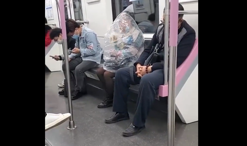 中国武汉地铁有女乘客将上半身套进塑胶袋后吃香蕉。（图撷自微博）(photo:LTN)