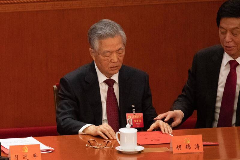 栗战书（右）被拍到中共二十大闭幕会上，似乎极力避免胡锦涛（左）翻看桌上的红色文件。（彭博）(photo:LTN)